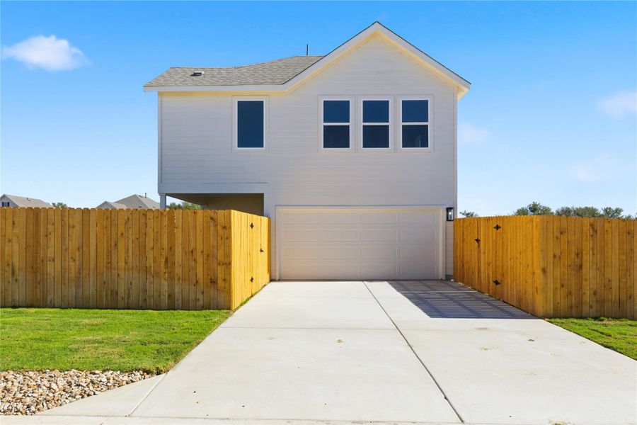 View of front facade with an attached garage, concrete driveway, and roof with shingles
