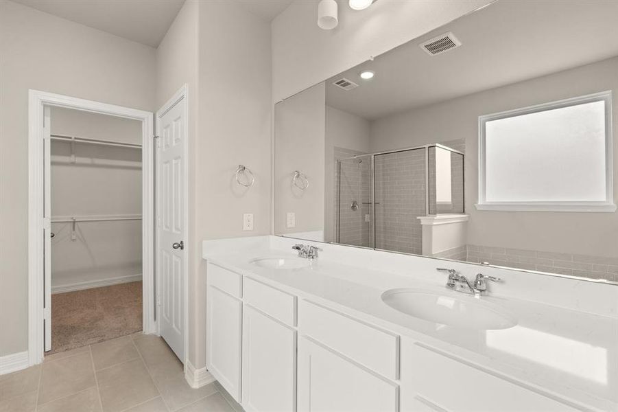 The en-suite bathroom offers a spa-like atmosphere with its elegant design, high end finishes, and tasteful lighting, creating a retreat within your own home.