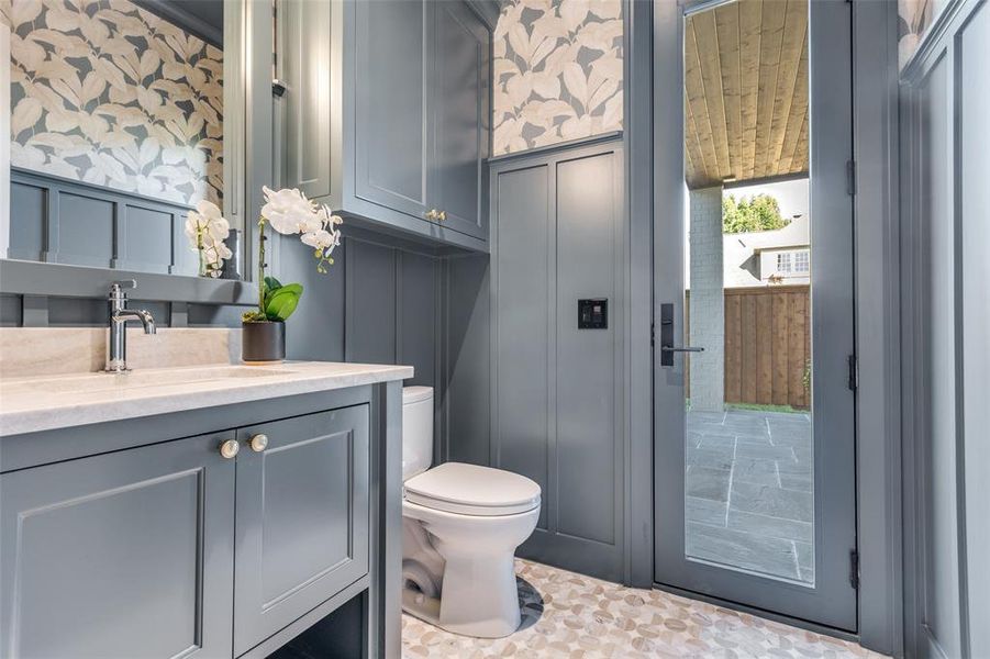 Half bath featuring vanity and wallpapered walls Half bath featuring vanity and wallpapered walls
