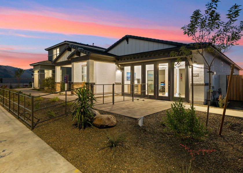 A building with a fence and a rock in front of it. A building with a fence and a rock in front of it.