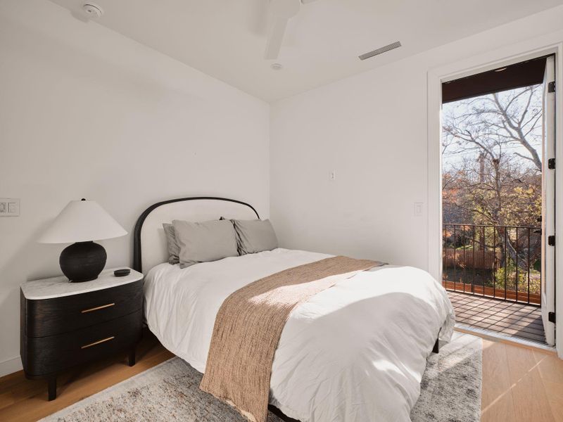 Bedroom with access to exterior, light wood-type flooring, and ceiling fan