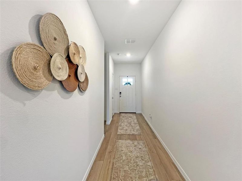 Corridor with light wood finished floors and baseboards
