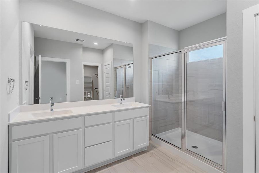 This primary bathroom is definitely move-in ready! Featuring white stained cabinets with light countertops, spacious walk-in closet with shelving, high ceilings, custom paint, sleek and dark modern finishes.