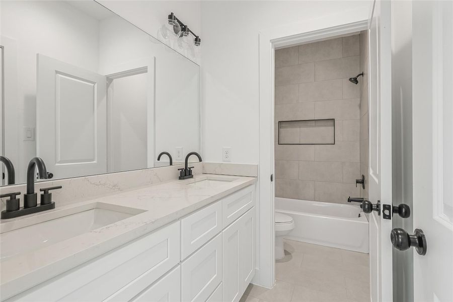 Bright and stylish secondary bathroom featuring a spacious dual sink vanity for added convenience and a versatile tub-shower combo, perfect for busy mornings and relaxing baths alike. A thoughtfully designed space that combines functionality with comfort, ideal for family living or guests.