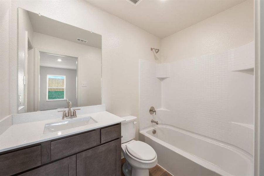 Full bathroom featuring vanity, bathtub / shower combination, wood-style flooring, and toilet