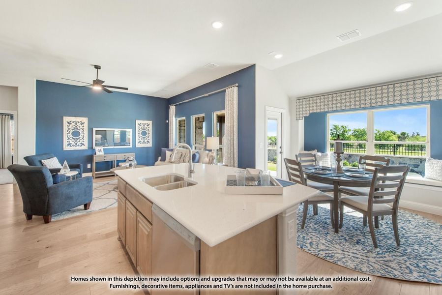 Open-concept kitchen with island sink, dining area, and living room with blue accent walls and hardwood floors Open-concept kitchen with island sink, dining area, and living room with blue accent walls and hardwood floors