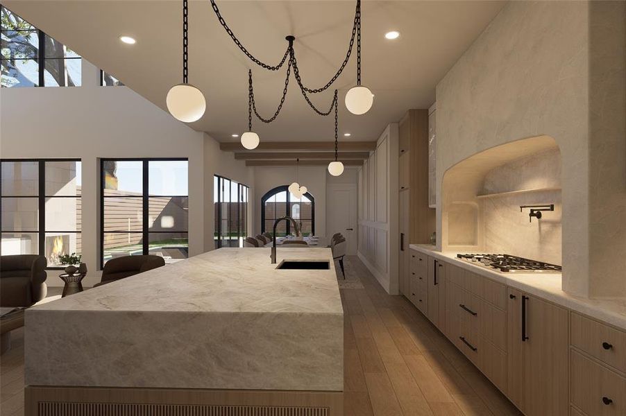 Kitchen with a spacious island, light stone counters, light wood-type flooring, hanging light fixtures, and light wood finish cabinetry