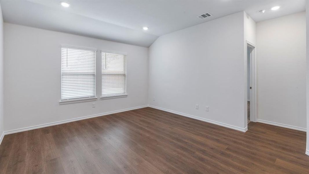 Empty room featuring lofted ceiling, dark wood-style floors, and recessed lighting