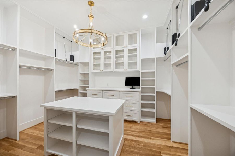Two expansive custom closets deliver boutique level storage and organization. Adjustable shelving, pull down hanging rods, drawer storage, and a center island allow clothing and accessories to stay visible, accessible, and beautifully organized for daily use. Two expansive custom closets deliver boutique level storage and organization. Adjustable shelving, pull down hanging rods, drawer storage, and a center island allow clothing and accessories to stay visible, accessible, and beautifully organized for daily use.