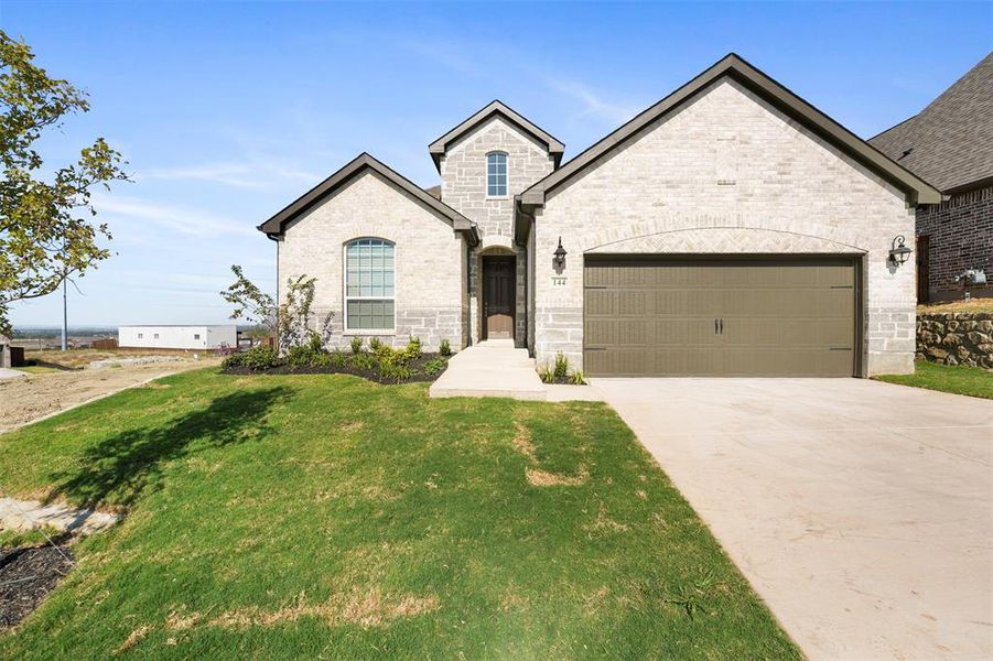 French country style house with a garage and a front lawn