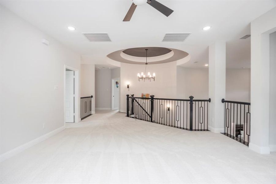 Carpeted spare room featuring recessed lighting, ceiling fan with notable chandelier, visible vents, and baseboards