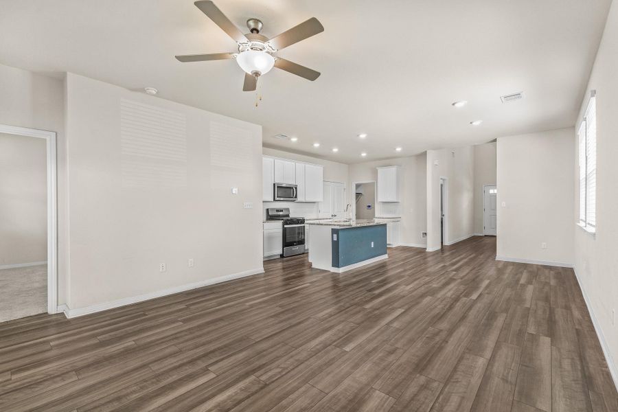 Unfurnished living room featuring recessed lighting, dark wood-style flooring, and a ceiling fan Unfurnished living room featuring recessed lighting, dark wood-style flooring, and a ceiling fan