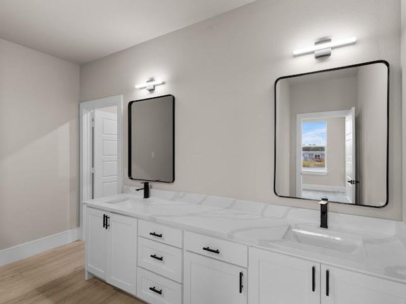 Bathroom with double vanity and light wood finished floors