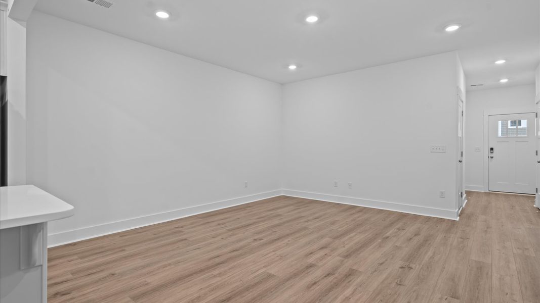 Spacious family room with rich hardwood flooring and elegant trim work in a reputable DRB Homes build Spacious family room with rich hardwood flooring and elegant trim work in a reputable DRB Homes build