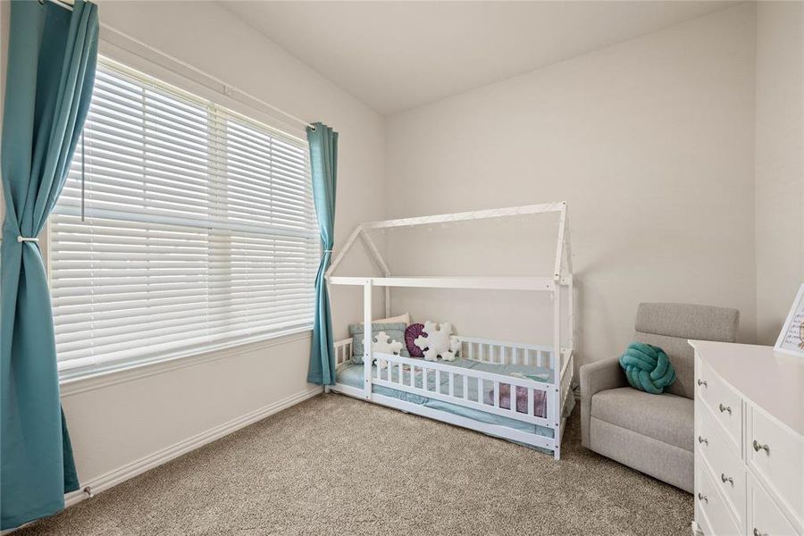 Bedroom with a crib and light carpet