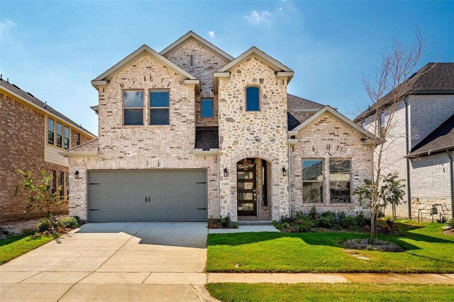 View of front of home featuring a garage and a front lawn