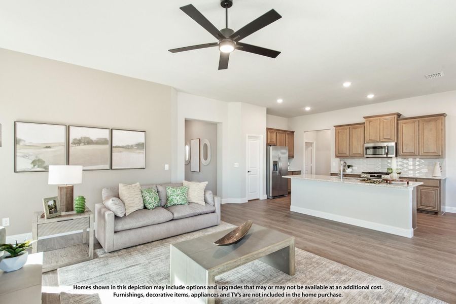 Open-concept living room and kitchen with hardwood floors, ceiling fan, and large island with wood cabinets Open-concept living room and kitchen with hardwood floors, ceiling fan, and large island with wood cabinets