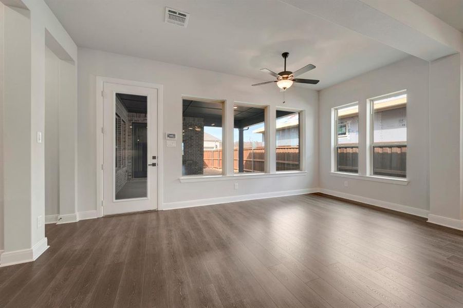 Empty room with ceiling fan and dark wood finished floors