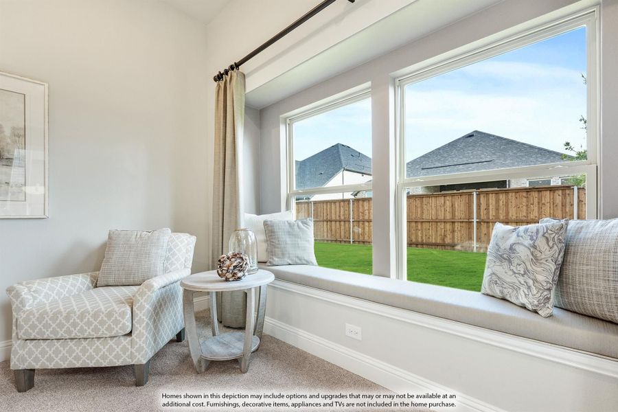 Sitting room with built-in window seat, accent chair, and large windows overlooking a fenced backyard Sitting room with built-in window seat, accent chair, and large windows overlooking a fenced backyard