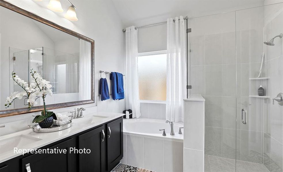Full bathroom featuring double vanity, a stall shower, and a garden tub