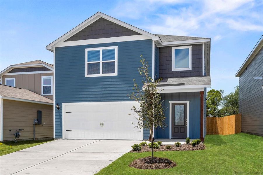 View of front facade with a garage and a front lawn