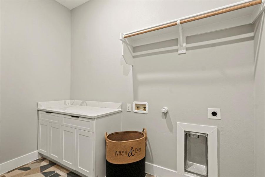 Washroom with electric dryer hookup, hookup for a washing machine, cabinet space, and hookup for a gas dryer