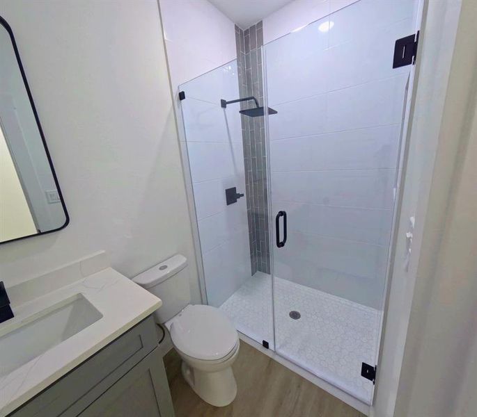 Full bath with vanity, light wood-type flooring, and a shower stall Full bath with vanity, light wood-type flooring, and a shower stall