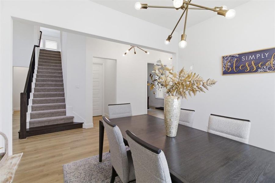 Open dining area featuring wood-finish flooring and a contemporary chandelier