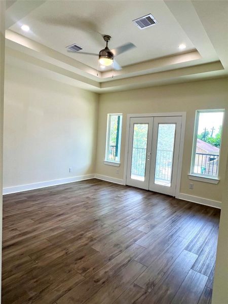 Spacious primary bedroom with a private balcony offering serene views of the front yard/driveway. Spacious primary bedroom with a private balcony offering serene views of the front yard/driveway.