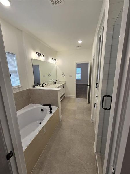 Bathroom featuring separate shower and tub, tile patterned floors, and vanity