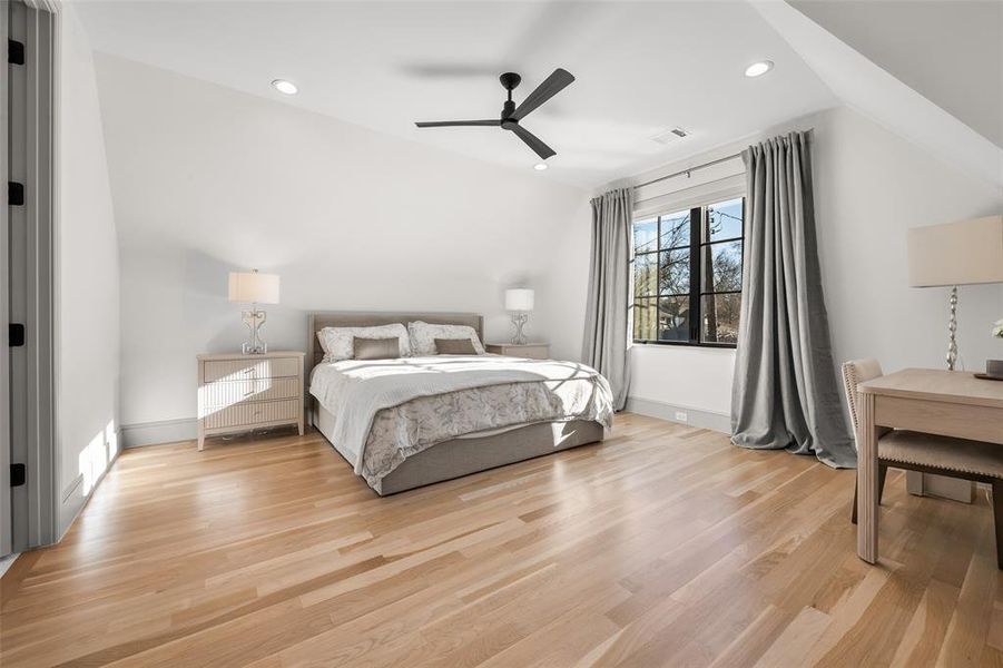 Bedroom with oak hardwood flooring, a ceiling fan, recessed lighting, and vaulted ceiling