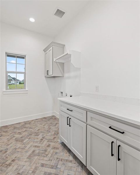Laundry area with cabinet space, recessed lighting, and hookup for a washing machine Laundry area with cabinet space, recessed lighting, and hookup for a washing machine