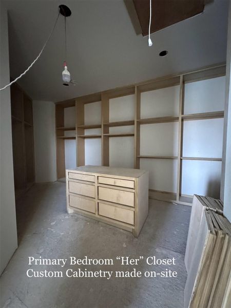 Expansive Custom 'Her' Closet with built-in Cabinetry, Island Dresser, and abundant storage. Handcrafted on-site for a truly tailored design.