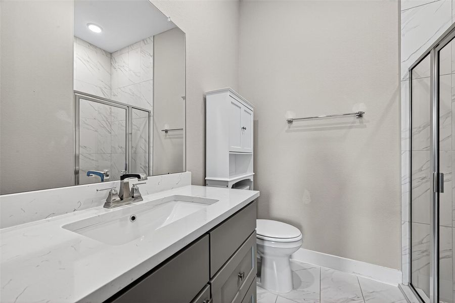 Secondary bathroom located inside secondary bedroom downstairs with oversized shower.