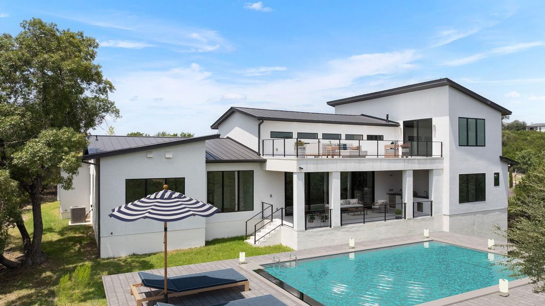 Virtually staged private backyard oasis features a glistening pool and multiple outdoor living spaces, perfect for entertaining.