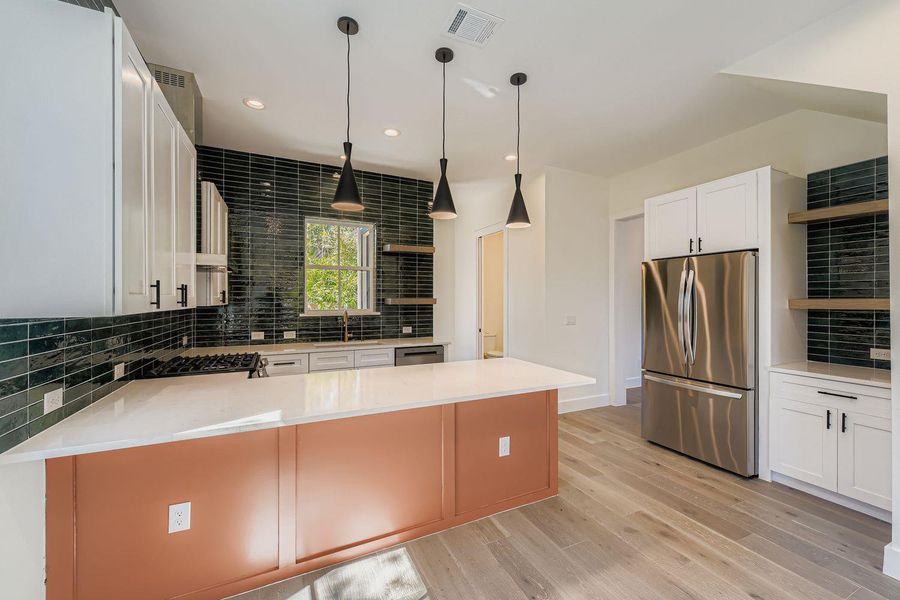 Kitchen with decorative backsplash, open shelves, stainless steel appliances, white cabinetry, and recessed lighting Kitchen with decorative backsplash, open shelves, stainless steel appliances, white cabinetry, and recessed lighting