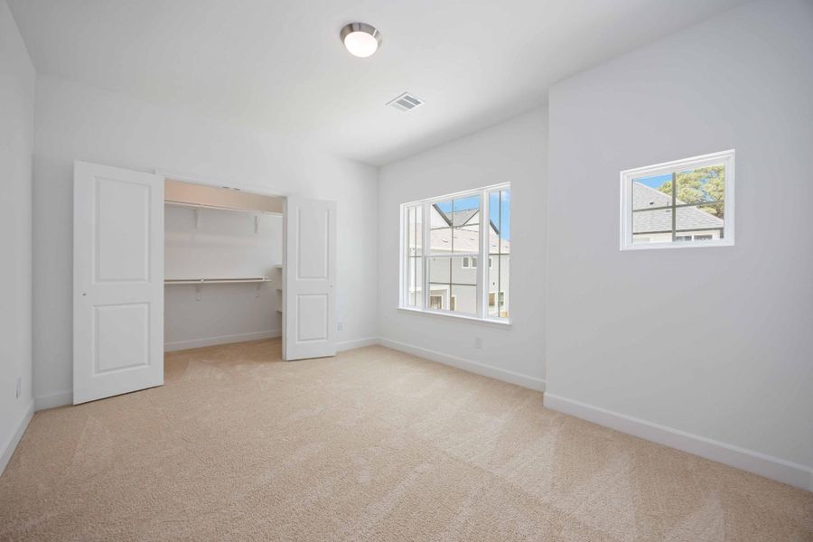 This secondary bedroom is spacious, sunny, and comes complete with a walk-in closet—ideal for guests, kids, or a stylish home office.