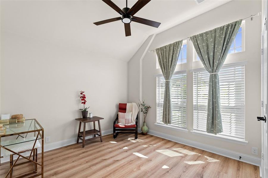 Sitting room featuring light wood finished floors, lofted ceiling, and a ceiling fan Sitting room featuring light wood finished floors, lofted ceiling, and a ceiling fan