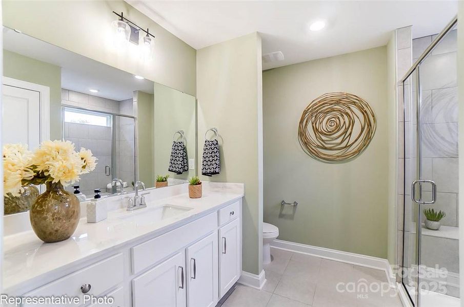 Primary bath features a double sink vanity and shower