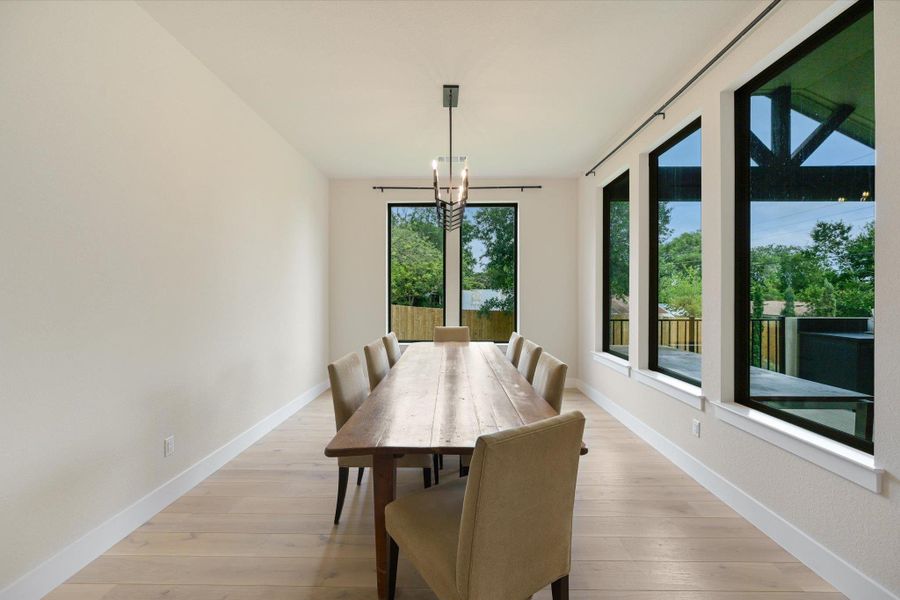 Natural light floods this dining room with abundant windows and hardwood flooring.
