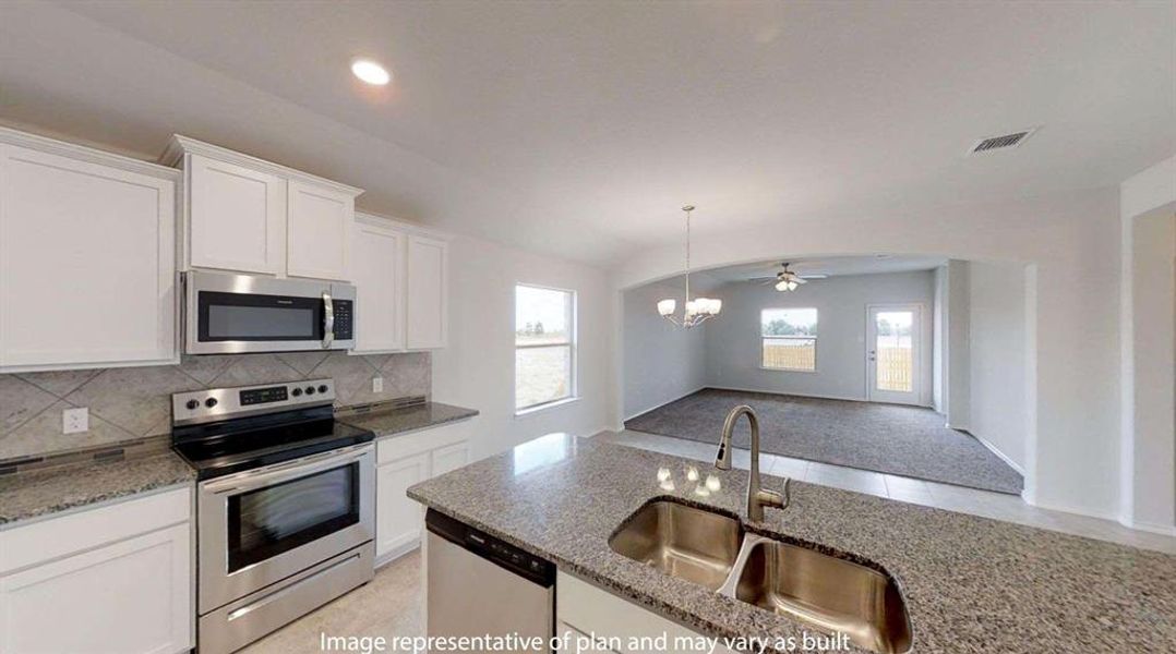 Kitchen featuring granite countertops, stainless steel appliances, a double basin sink with a high-arc faucet, white cabinetry, and a tile backsplash Kitchen featuring granite countertops, stainless steel appliances, a double basin sink with a high-arc faucet, white cabinetry, and a tile backsplash
