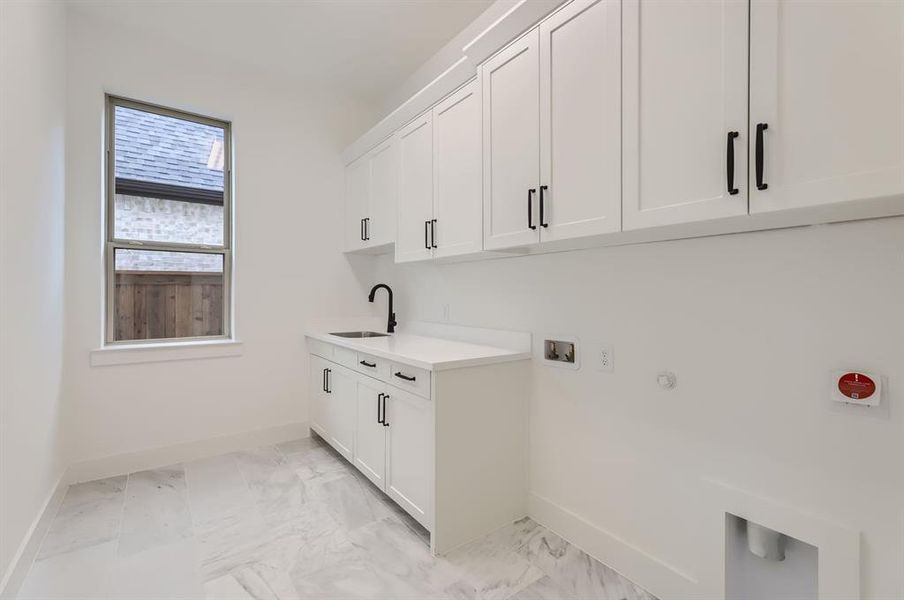 Washroom featuring washer hookup, gas dryer hookup, cabinets, and sink