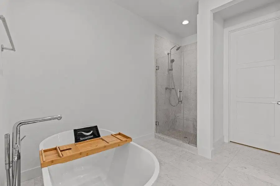 Marble flooring pair with a modern soaking tub and glass-enclosed shower. Marble flooring pair with a modern soaking tub and glass-enclosed shower.
