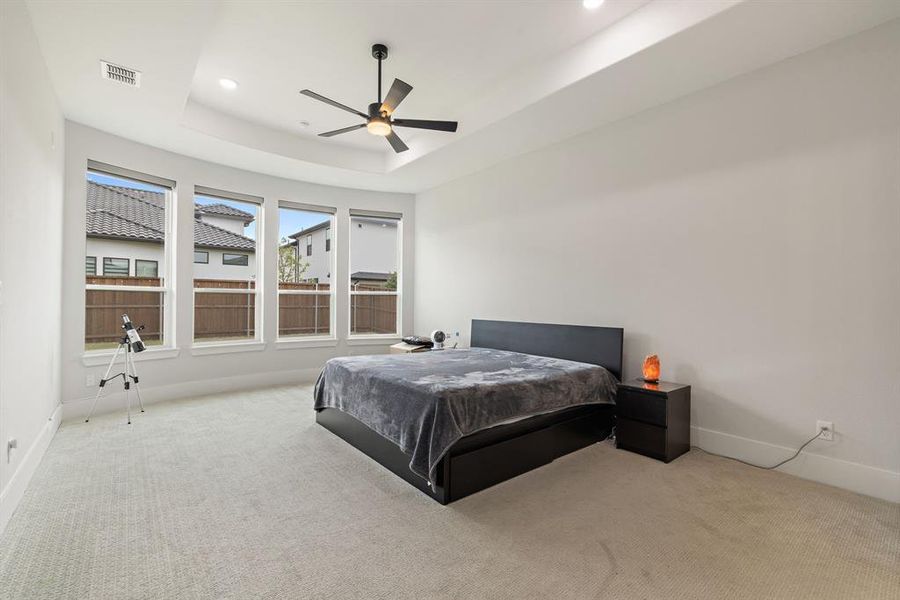 Bedroom with a raised ceiling, carpet, recessed lighting, and ceiling fan