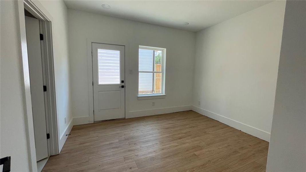 This is a bright, secondary bedroom located on the first floor. Windows for natural light, and a door leading to the yard, offer a clean canvas for personalization.