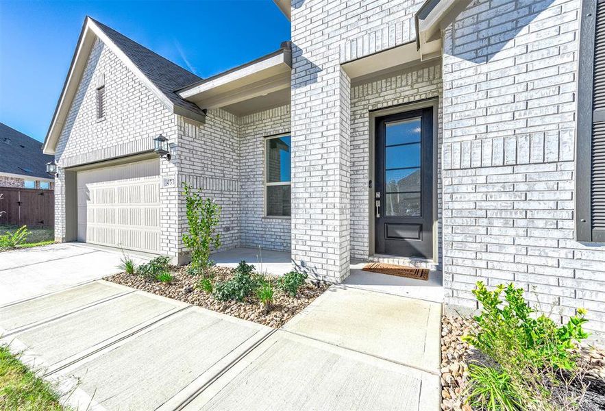 Step into elegance! The covered front porch and sleek modern door invite you into this stunning home.