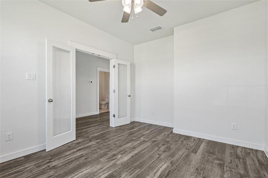 Unfurnished room with ceiling fan and dark hardwood / wood-style flooring