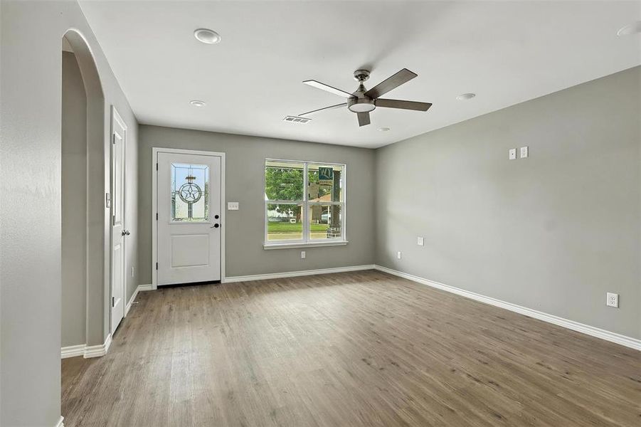 Entryway with ceiling fan, wood finished floors, and arched walkways Entryway with ceiling fan, wood finished floors, and arched walkways