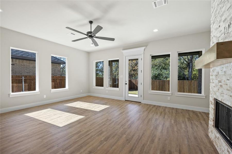Unfurnished living room featuring wood finished floors, a fireplace, ceiling fan, and recessed lighting
