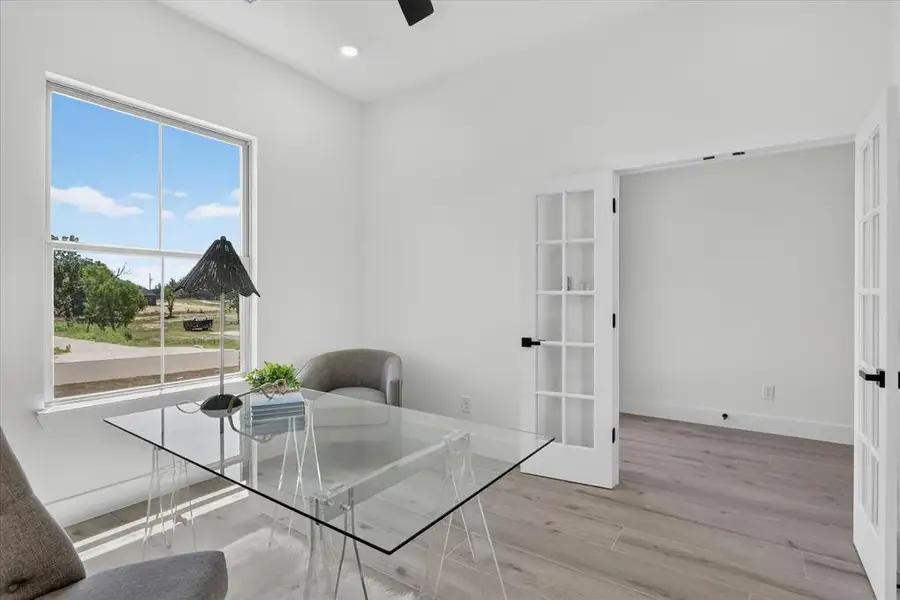 Bright room featuring a large window, recessed lighting, and wood-finish flooring